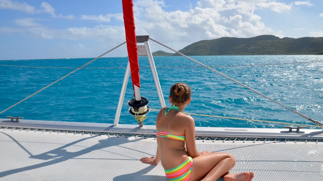 a lady in a bikini sitting on a yacht in the middle of the sea