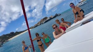 a group of ladies in bikinis having fun on a yacht